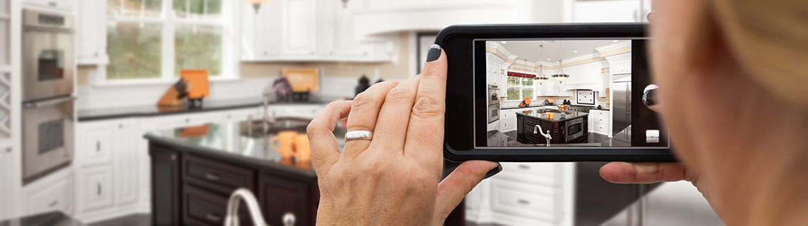 Person taking a picture of a kitchen with their smartphone