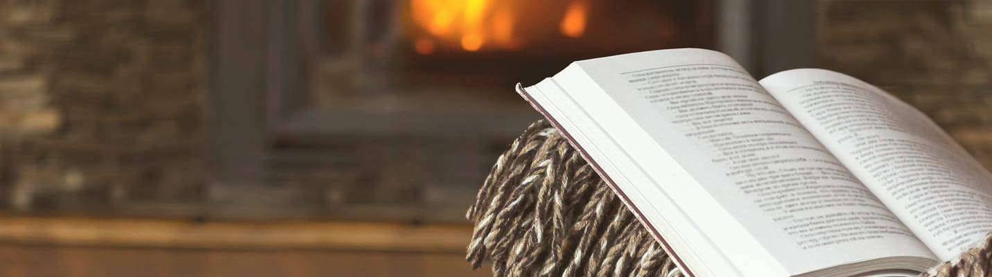 reading a book by the fireplace