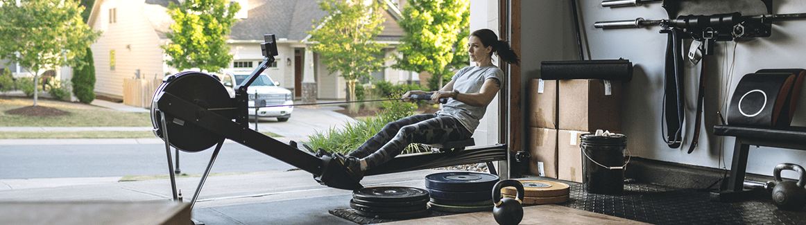 Woman on a home gym machine in a garage