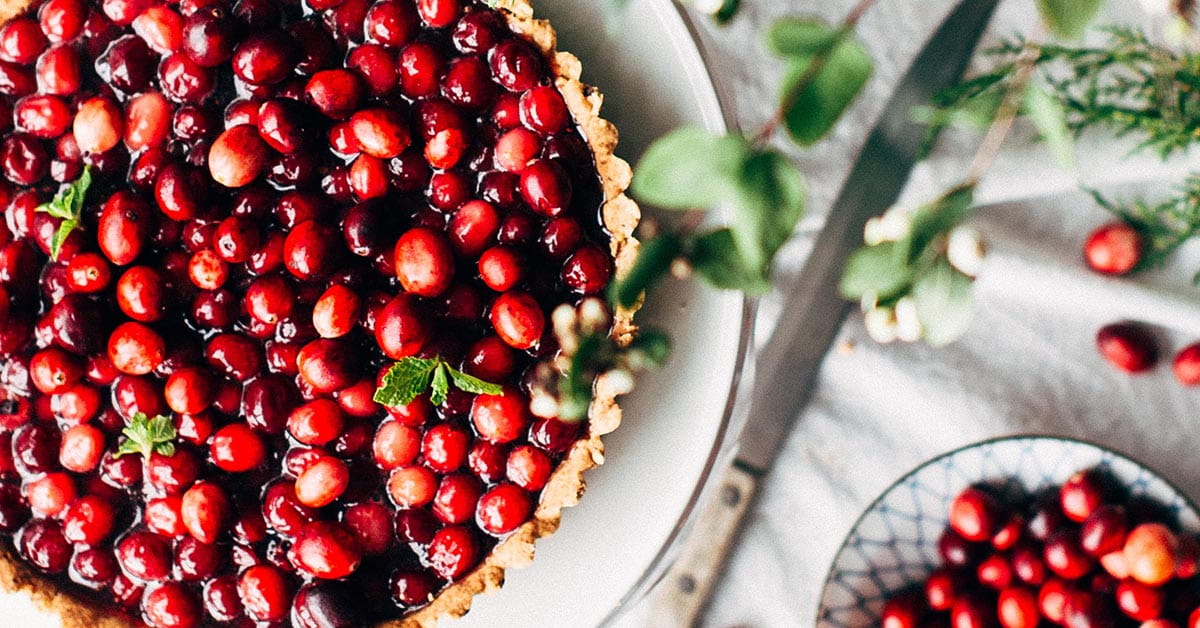 Cranberry pie and a plate of cranberries on a table