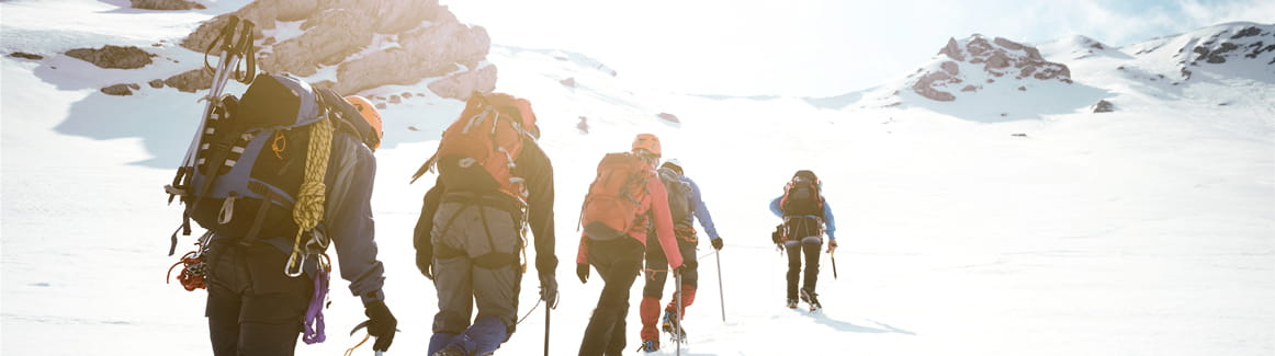 Group of people climbing a snowy mountain