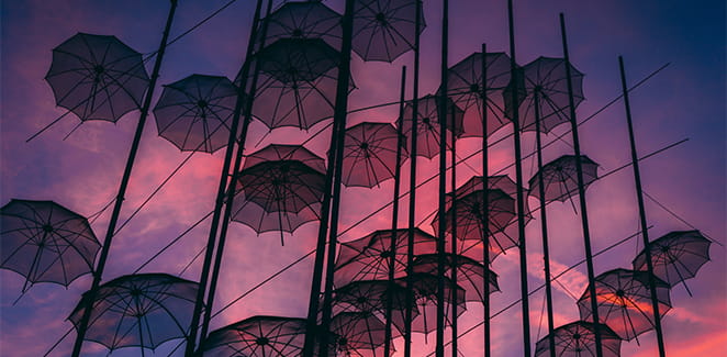 Looking up on umbrellas stuck on wires at dusk