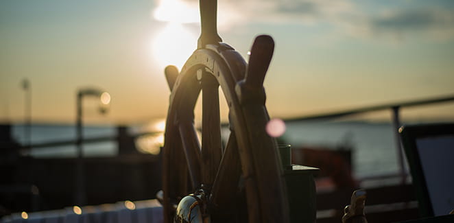 Boat wheel at sunset