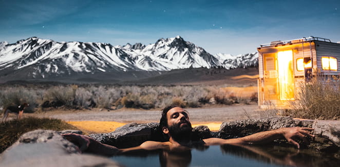 Man in mountain hot spring campsite