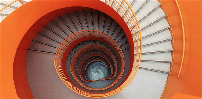 Orange spiral staircase viewed from the top down
